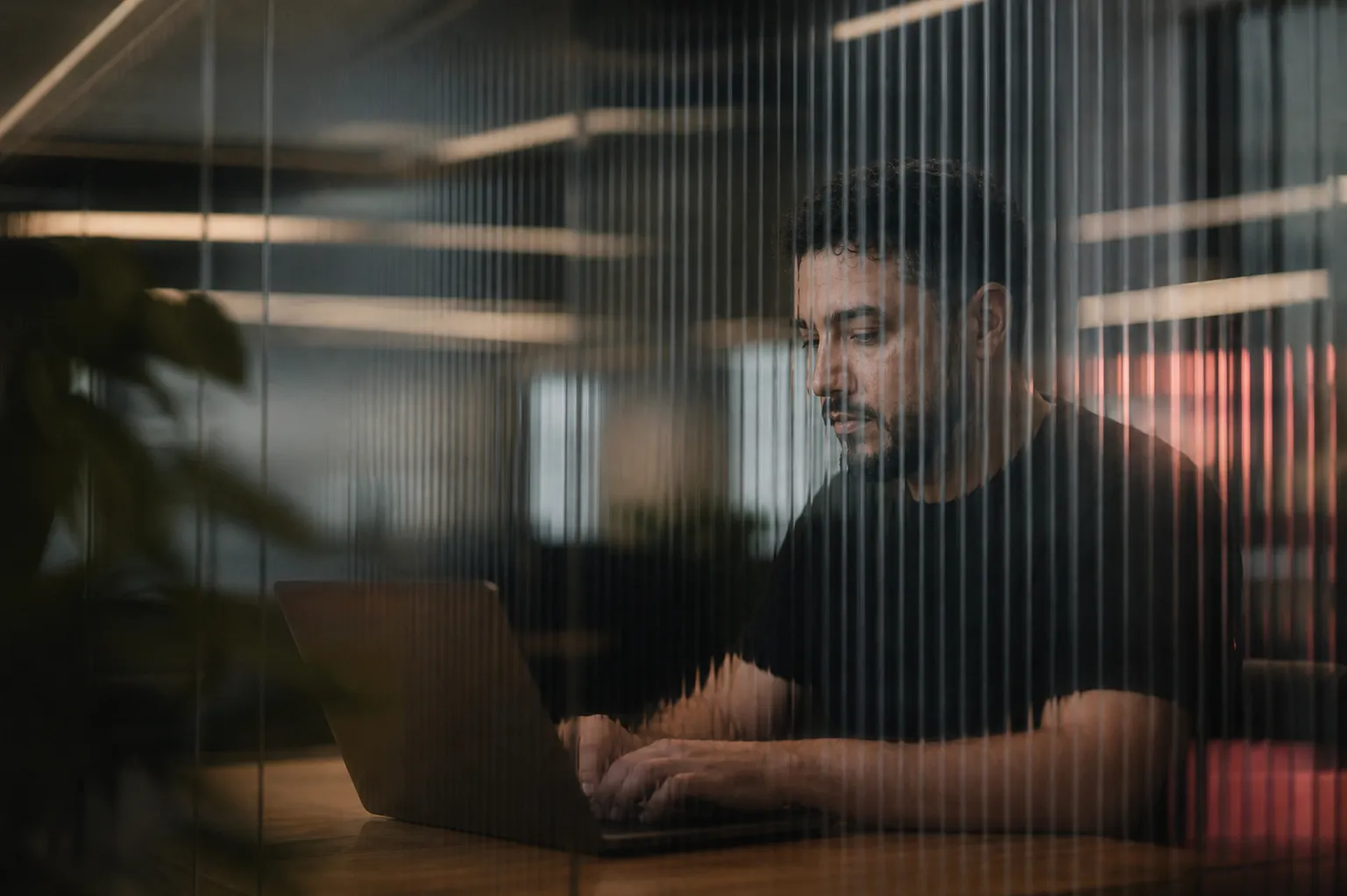 Profissional trabalhando em um notebook no estúdio que conduz a operação da Obbi